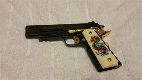 A 1911 pistol with various gold accents