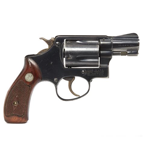 A.38 Special handgun with a red grip, lying on a wooden table