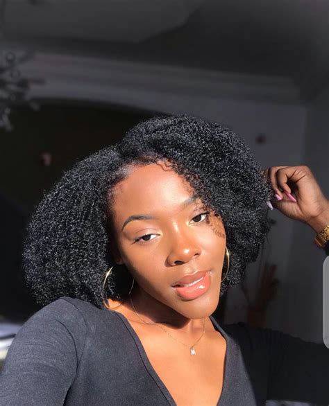 A young woman with 4c hair styled in a braided updo, paired with Air Force Ones