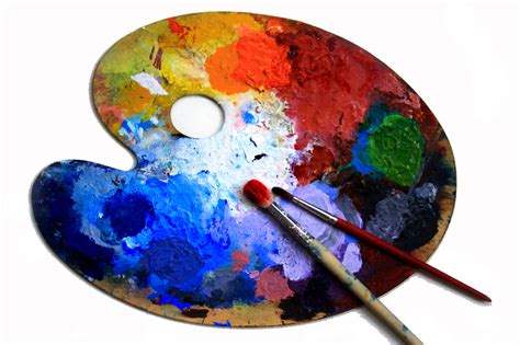 An artist mixing colors on a wooden palette