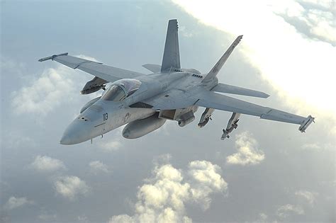 F/A-18 Hornet in action, conducting a strike mission over a desert landscape