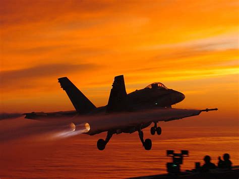 F/A-18 Hornet flying over a sunset landscape