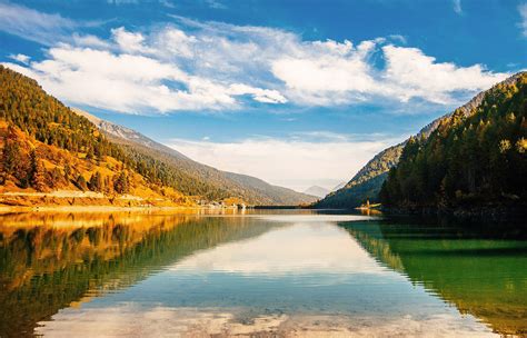 A serene landscape with a calm lake and rolling hills