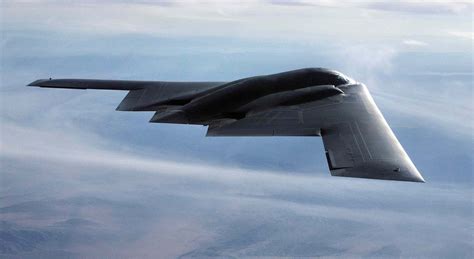 A B-2 Spirit stealth bomber flying over a runway