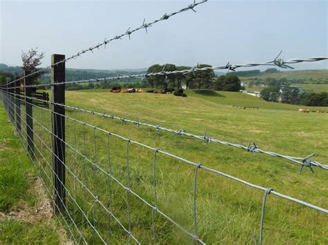 A barbed wire fence surrounding a farm