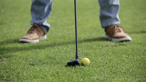 Golfer demonstrating the basic swing with a hybrid golf club