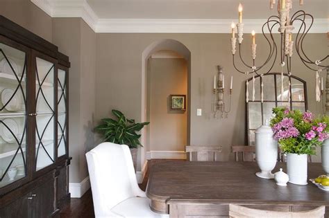 A dining room with cream-colored walls and taupe-colored furniture