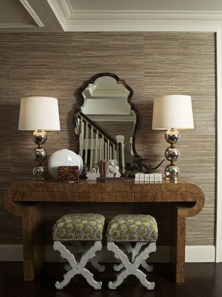 An entryway with cream-colored walls and taupe-colored furniture