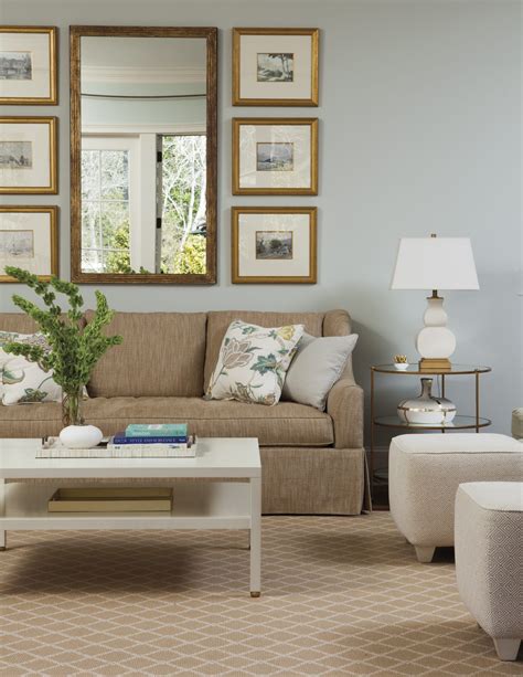 A living room with cream-colored walls and taupe-colored furniture