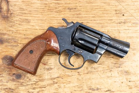 A.38 Special handgun with a red grip, lying on a wooden table