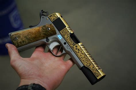 A close-up of gold inlays on a 1911 pistol