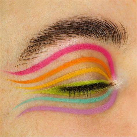 A makeup artist using a graphic liner palette to create a design on a model's face