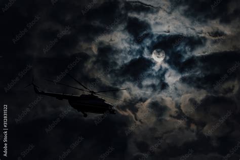 A helicopter flying through the skies, with a cityscape in the background