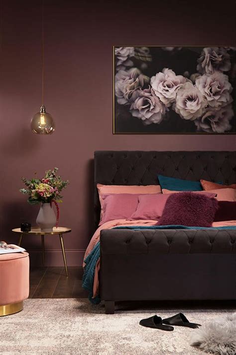 A mauve-colored bedroom with a bold accent wall