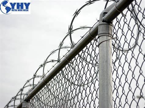 A modern barbed wire fence surrounding a farm