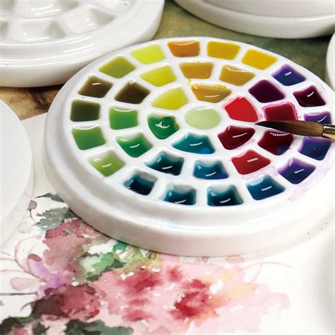 A porcelain paint palette with watercolor paints