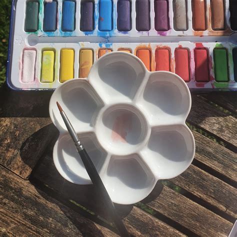 A porcelain paint palette with watercolor paints