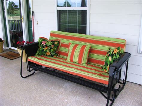 A cozy porch glider with pillows and a book