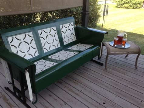 A porch glider with outdoor decor and plants