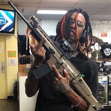 A rapper holding a gun