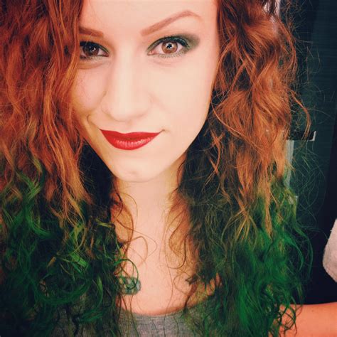 A person with red hair and an emerald green dress