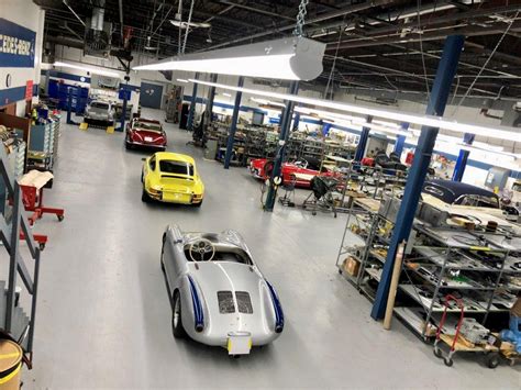 A hot rod in a restoration shop, surrounded by tools and parts