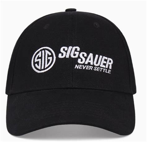 Man wearing a Sig Sauer cap with a pair of boots