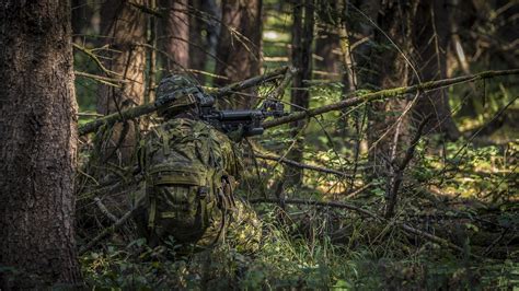 Soldier with gun in forest environment