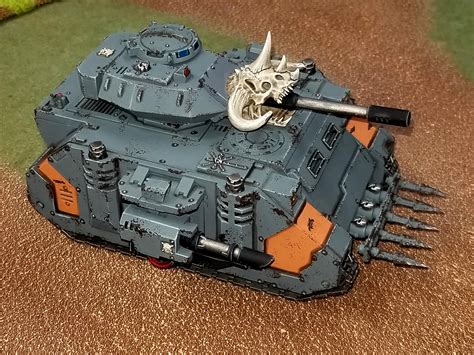 A Space Marine tank rolling over enemy positions