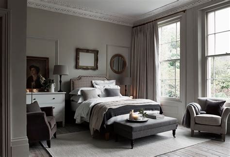 A bedroom with taupe-colored walls and cream-colored bedding