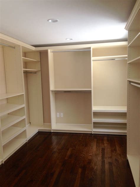 A closet with taupe-colored walls and cream-colored shelves