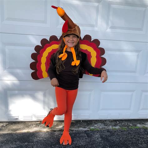 A kid wearing a turkey superhero costume