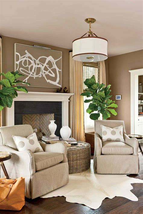 A living room with cream-colored walls and taupe-colored furniture featuring modern accents