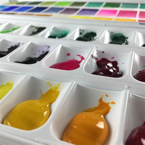 Watercolor palettes on a wooden desk